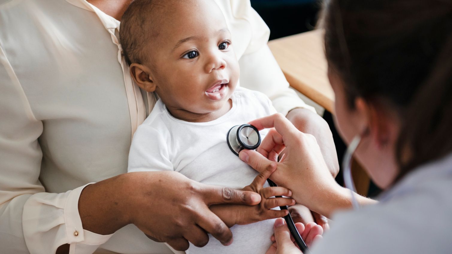 A female doctor checks the heartbeat of a young child